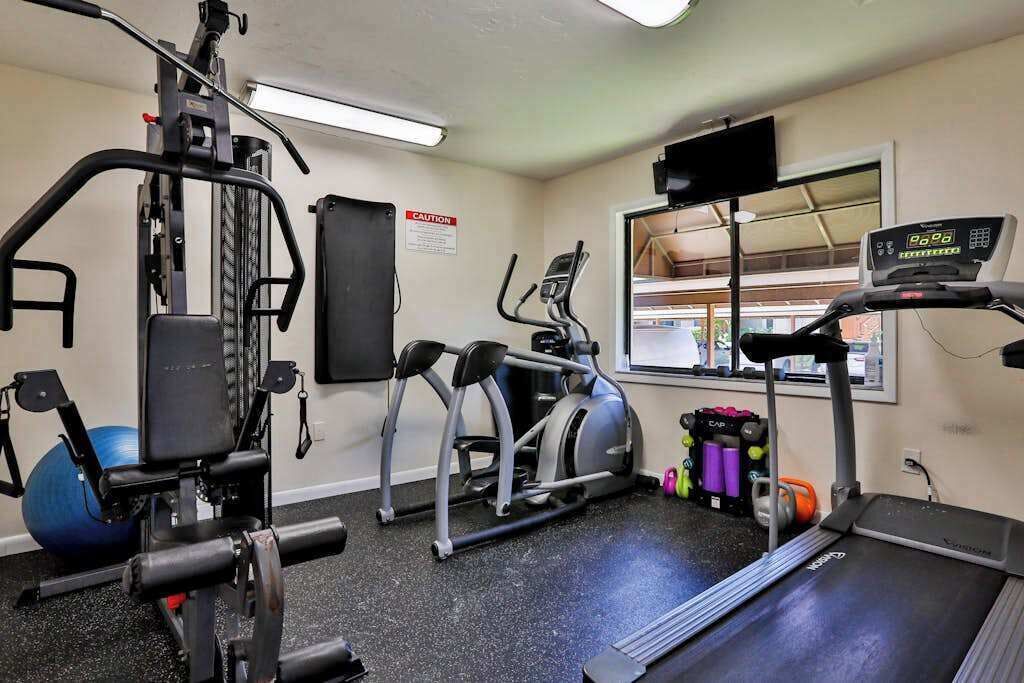 A gym with exercise equipment, a treadmill, and a window with a view.
