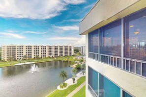 Een modern gebouw met grote ramen, een binnenplaats met een fontein en een waterpartij.