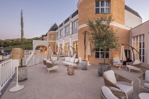 A rooftop terrace with outdoor seating, a large tree, and a view of the surrounding landscape. - Castelos do Vale by Livá OFICIAL (Vale dos Vinhedos)