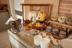 Una mesa de buffet con una variedad de quesos, frutas y frutos secos.