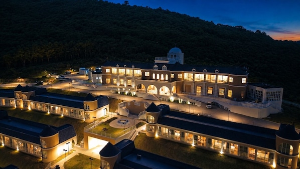 A large, multi-story hotel with a central courtyard, multiple wings, and a dome structure.