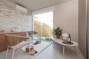 Una cocina moderna con salpicadero de piedra, un comedor con mesa redonda y vistas al exterior.