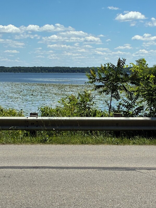 A view of a lake with a concrete barrier in the foreground and a distant shoreline. - Quaint 2-bedroom cottage in charming Andover perfect for relaxing getaway. (Andover)