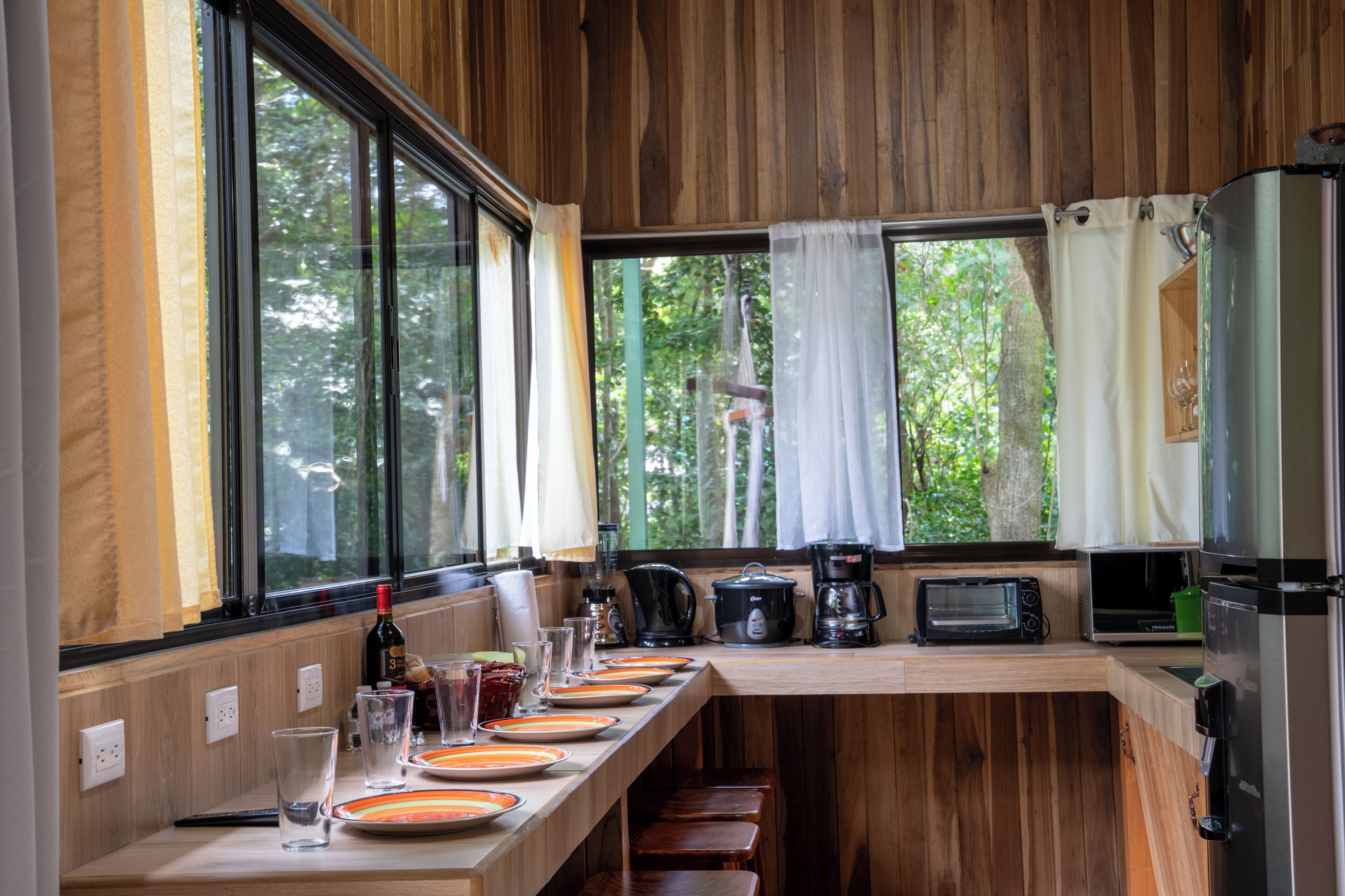Una cocina con una encimera amplia, cafetera, tostadora y refrigerador.