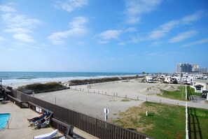 A beach view with a pool, lounge chairs, and RVs. - Land's End Resort - Relaxing Oceanfront Getaway with Private Balcony & Resort Am (Myrtle Beach)