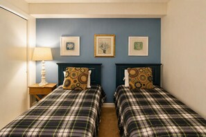 A room with two beds, a nightstand with a lamp, and three framed pictures on the wall. - Land's End Resort - Oceanfront Views & Resort Amenities (Myrtle Beach)