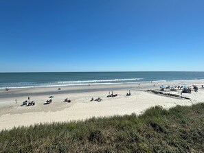 A beach with clear skies, a sandy shore, and several beach umbrellas. - Land's End Resort - Family Retreat with Ocean Views, Pools & Spacious Layout (Myrtle Beach)