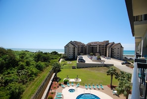 A hotel with a pool, multiple floors, and a view of the ocean. - Ocean View | King Suite, Balcony & Beach Access (Myrtle Beach)