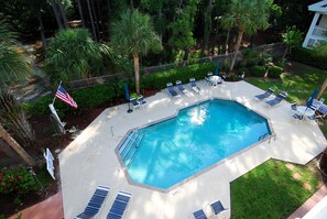 Piscina com espreguiçadeiras e a bandeira americana.