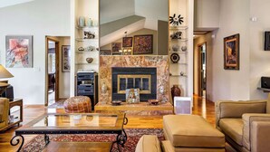 A spacious living area with a fireplace, comfortable seating, and a high ceiling. - Garden Trails! Spacious Home by Garden of the Gods (Colorado Springs)