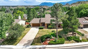 A residential area with houses, a driveway, and a mountain backdrop. - Garden Trails! Spacious Home by Garden of the Gods (Colorado Springs)