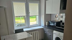 Une cuisine compacte avec une fenêtre, un lave-linge et un coin repas.