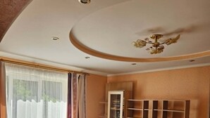 A living room with a sofa, a television, and a cabinet. - Serene 1-bedroom apartment in charming Liepāja perfect for relaxing (Liepāja)