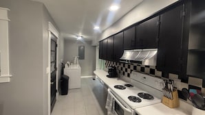 Una cocina moderna con estufa, horno y armarios negros.