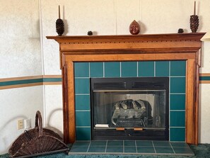 A fireplace with a wooden mantel and a tiled surround.
