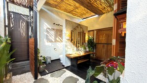 A bathroom with a wooden vanity, a mirror, a sink, and a toilet.
