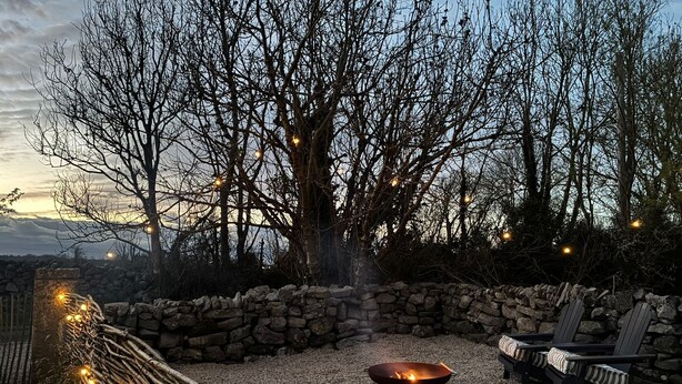 A stone wall, a fire pit, and outdoor seating.