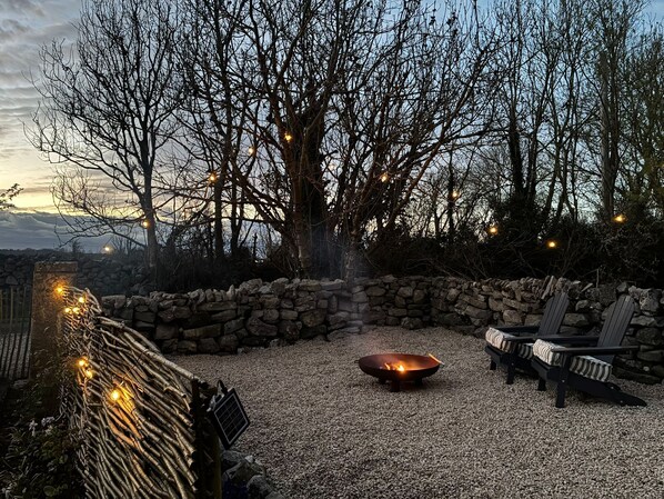 A stone wall, a fire pit, and outdoor seating.