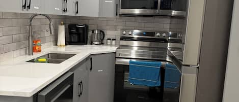 A modern kitchen with stainless steel appliances, a built-in oven, and a microwave.