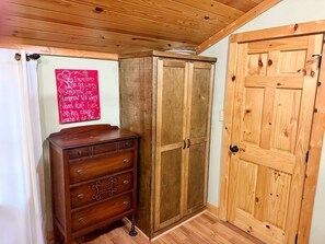 A wooden cabinet with a mirror, a wooden door, and a red sign on the wall. - Charming 2-bedroom country house 15 minutes from Bryan with AC/Heat. (Bryan)
