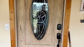 A wooden door with a glass panel, a keypad lock, and a doorbell. - Charming 2-bedroom country house 15 minutes from Bryan with AC/Heat. (Bryan)