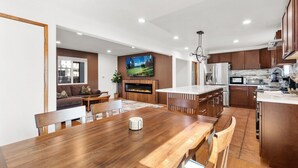 A modern kitchen with wooden cabinets, a central island, and built-in appliances. - Walk to Lake Tahoe | Sleeps 10 | EV Charger (South Lake Tahoe)