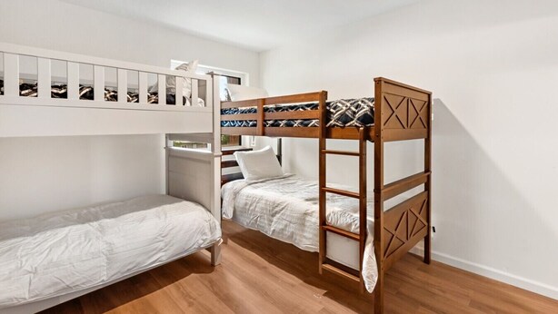 A bunk bed room with a wooden ladder, a small desk, and a mirror above the bed. - Walk to Lake Tahoe | Sleeps 10 | EV Charger (South Lake Tahoe)