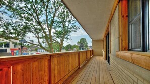 A wooden deck with a view of trees and buildings.