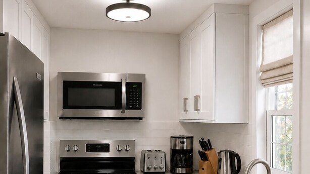 A modern kitchen with stainless steel appliances, a built-in oven, a microwave, and a sink. - Oceanview Cottage - Beach - Peaceful - Amazing Views (Cottage Name= Dune View) (Malpeque)