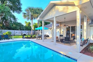 A covered outdoor area with a pool, patio furniture, and a barbecue grill. - Private Pool • 5 Min to Beach • Game Room • BBQ (Panama City Beach)