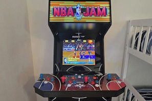 Una máquina de arcade con el juego NBA JAM, mostrando una cancha de baloncesto y controles del juego.