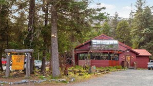 A rustic cabin with a red exterior, a visible entrance, and a signboard indicating a 'Double Musky Inn.'