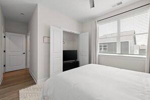 Un dormitorio con una cama grande, un vestidor y una ventana con persianas.