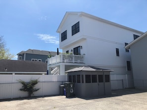 Ein zweistöckiges Wohnhaus mit Balkon, Garage und umzäunter Garten.