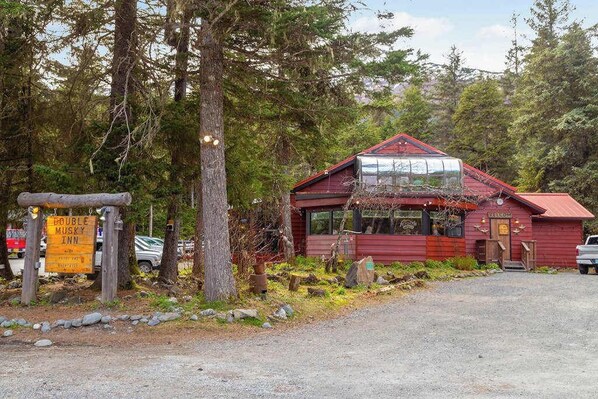 A rustic cabin with a red roof, a glass front, and a signboard indicating a double room and a musky inn.