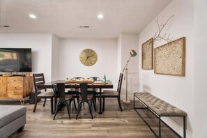 A modern dining area with a wooden table, chairs, a clock, and a bench. - 4 bedroom accommodation in La Verkin (La Verkin)