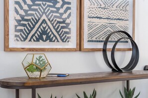 A wooden table with a hexagonal glass terrarium, a pen, and two black rings. - 4 bedroom accommodation in La Verkin (La Verkin)