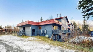 Een gebouw met twee verdiepingen, een rood dak, een balkon en een trap naar de bovenverdieping.
