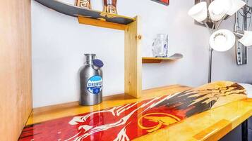 Una repisa de madera con una botella de agua de metal, un vaso y una tabla de surf.