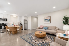 Un appartement moderne comprenant une cuisine, un coin repas et un salon.