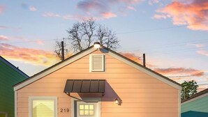 A single-story building with a gabled roof, a front door, and a small porch area. - Iberville Inn•2 Kings•Family Friendly•FastWiFi (Lafayette)