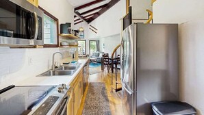 A modern kitchen with stainless steel appliances, wooden cabinets, and a built-in oven.