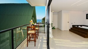 Un interior moderno con un balcón, una zona de comedor y una escalera.
