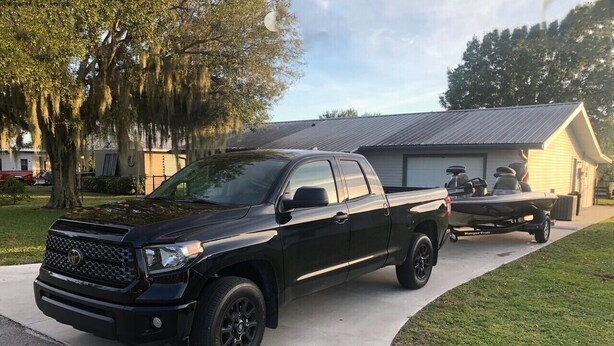 Ein schwarzer Pick-up-Truck steht auf einer Auffahrt vor einem Haus mit Garage.