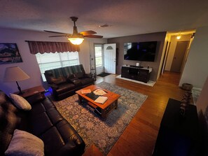 Ein Wohnzimmer mit einer Couch, einem Couchtisch und einem Fernseher.