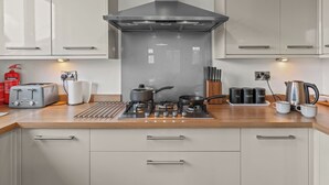 Una cocina moderna con estufa a gas, tostadora y cafetera.