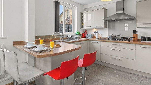 Una cocina moderna con barra, electrodomésticos de acero inoxidable y vistas al exterior.