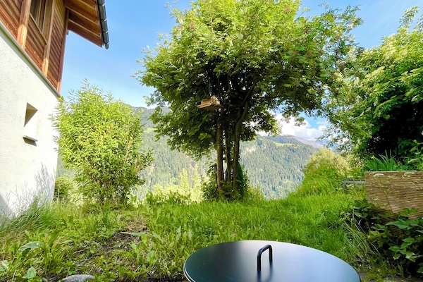 Scenic mountain-view patio with lush garden and cozy outdoor fire pit