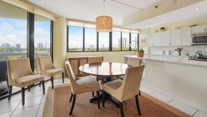 A modern kitchen with a dining area, large windows, and a city view. - Unit for RENT in Miami, Aventura area. Six months MINIMUM. (Miami)