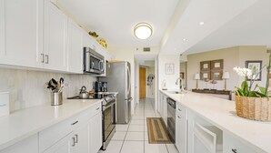 A modern kitchen with white cabinets, stainless steel appliances, and a bright ceiling light. - Unit for RENT in Miami, Aventura area. Six months MINIMUM. (Miami)